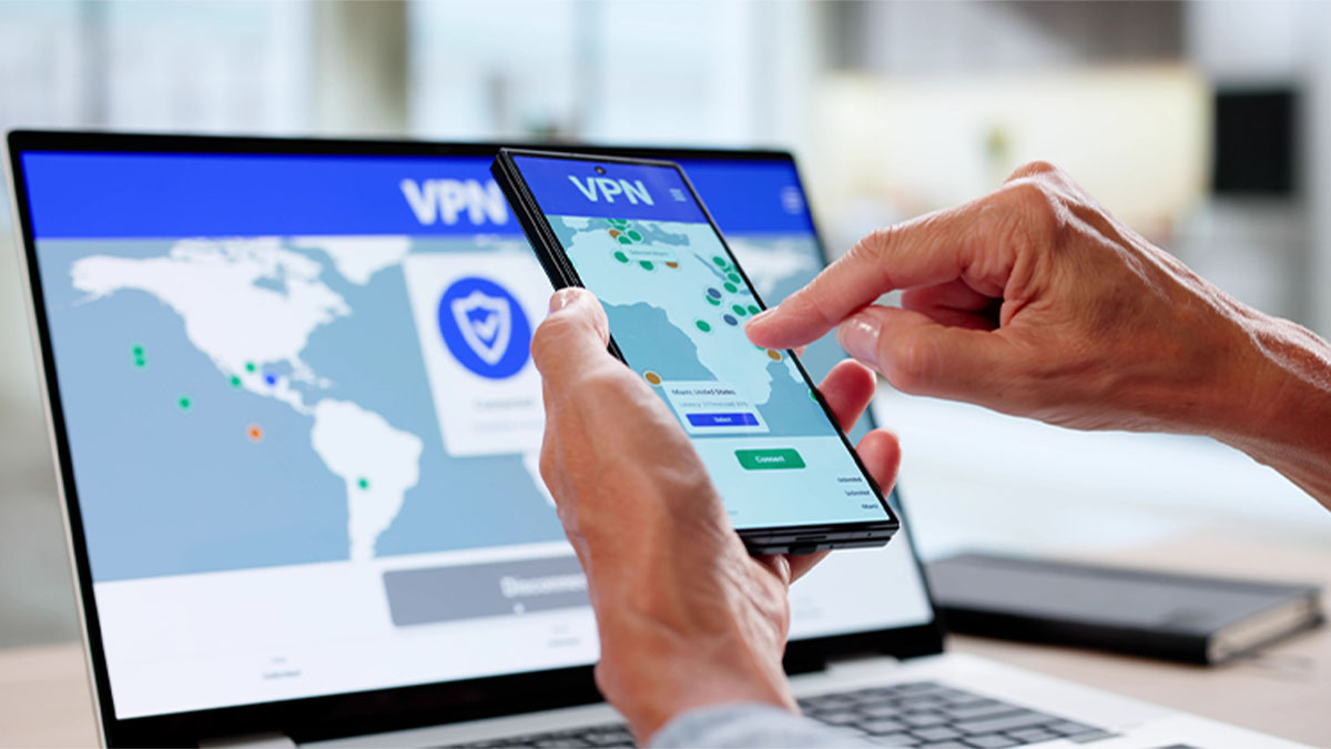 Pessoa a usar VPN em computador e smartphone